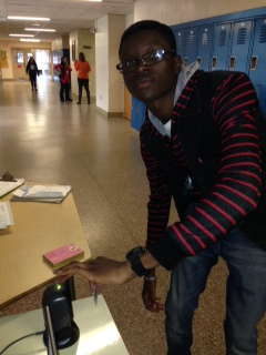 Yusuff Azeez demonstrates how students have to scan in to go to the bathroom now. 