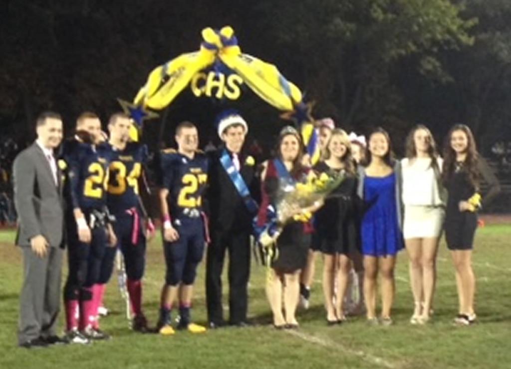 Senior homecoming nominees posing with the winning homecoming queen and kind. 
