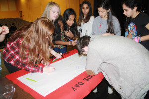 Members of the Thespian Society sign a World Aids Day commeriative banner. 