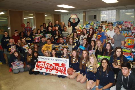Students take a picture with all the toys that were collected.