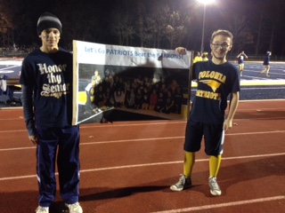 Cheerleaders Matthew Cowan and John Fantell hold up a sign while riling up the fans.