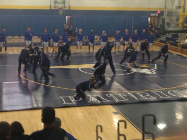 The Colonia Team warms up on the mat before starting their match