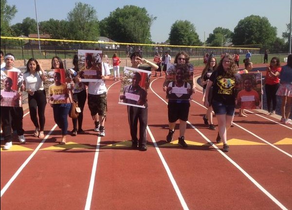 Holding pictures of the students in Uganda , students at Colonia High are reminded of why this walk is important. 