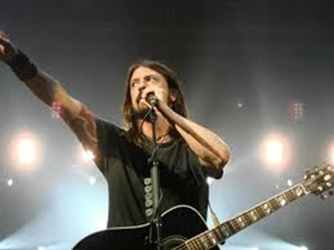 Lead singer of the Foo Fighters, Dave Grohl on stage reaching out to his fans