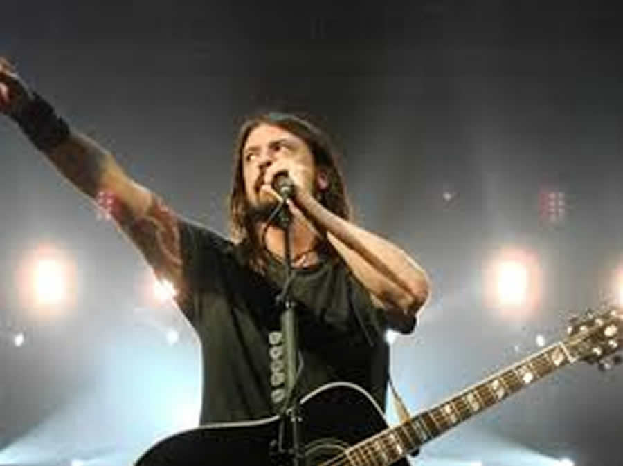 Lead singer of the Foo Fighters, Dave Grohl on stage reaching out to his fans.