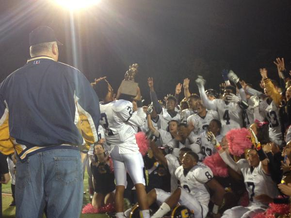 Senior Captain and Quarterback brings the Township Police Trophy to his Colonia teammates.