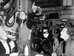 Burgess Meredith as The Penguin (far left), Frank Gorshin as The Riddler (second to the left), Julie Neymar as Catwoman (second to the right), Caesar Romero as The Joker (far right) make up some of the greatest supervillains of all time.