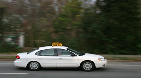  Teenager practicing driving during a driving course.