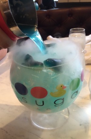 The Sugar Factory's signature goblet "Ocean Blue", steaming with shark gummies around.