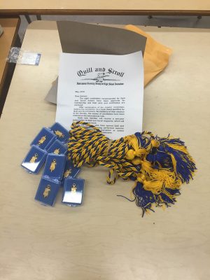 Chords, pins, and certificates for the new members of the Quill and Scroll Society
