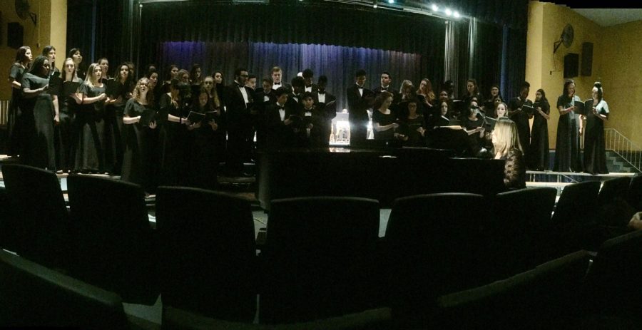 The choir stood, to sing their next song during the concert. 