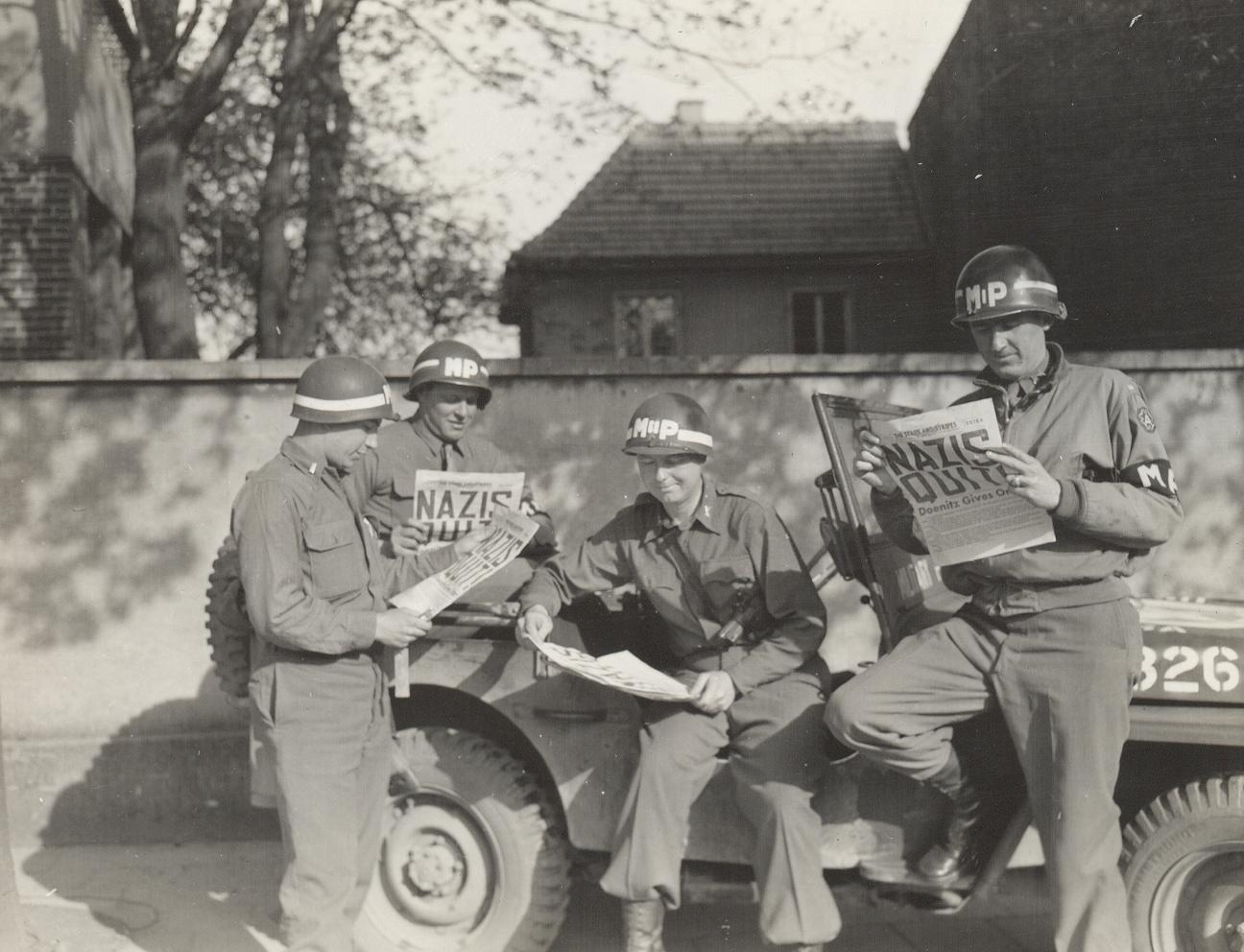 4_US_MPs_reading_about_German_surrender_army.mil-2007-05-07-132957