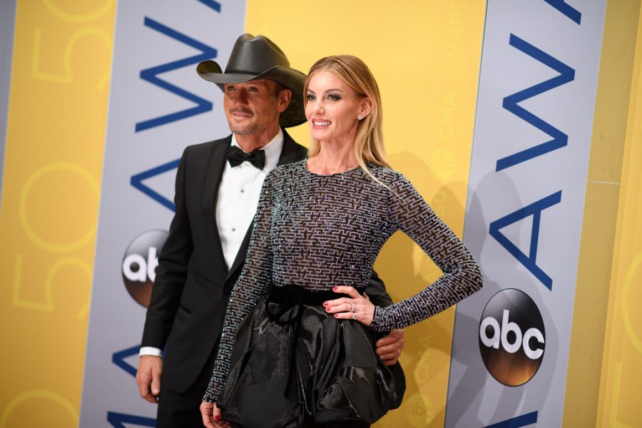 Posing for a photograph on the red carpet, Faith Hill and Tim McGraw stand side by side. 