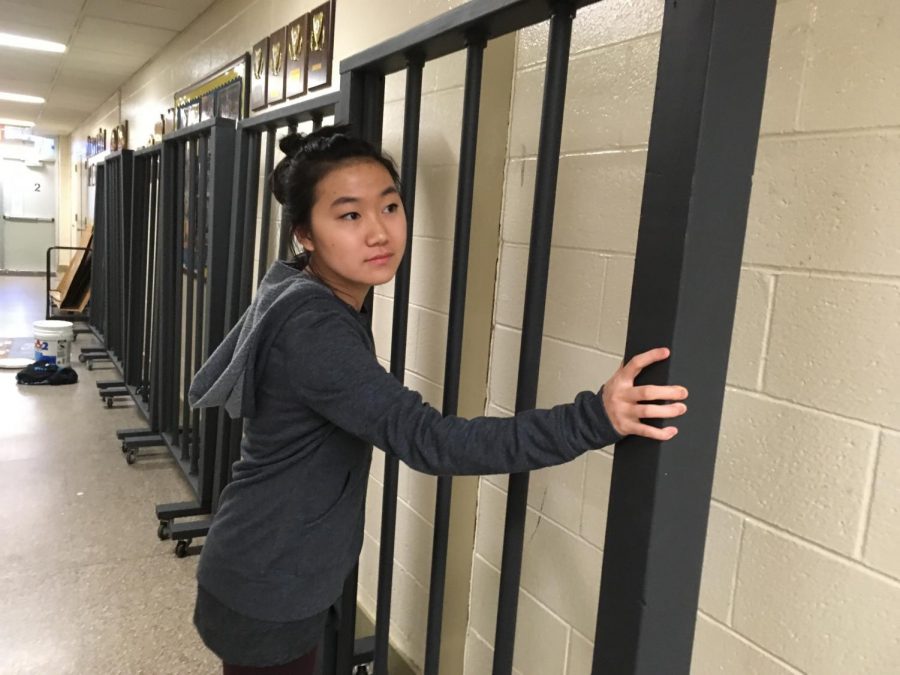 Senior Stage Crew Member Melissa Ngai begins to move jail cells backstage. 