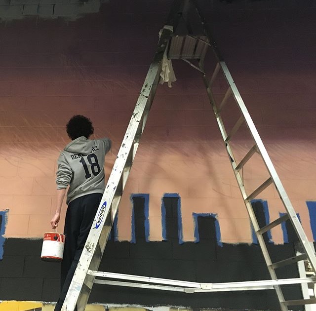 Scenic artist Thomas Demkowicz painting the back wall.