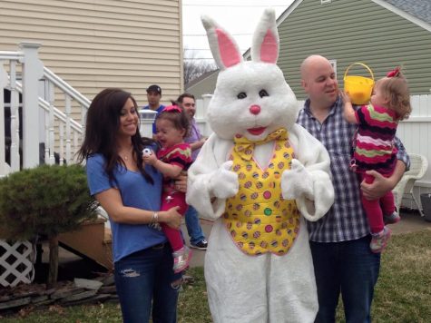 Meeting the Easter Bunny, Bryn Ellmyer clings to her mother, Melissa Ellymer in fear while twin sister Alissa hides her face from the bunny while father, Steven Ellmyer holds her. 