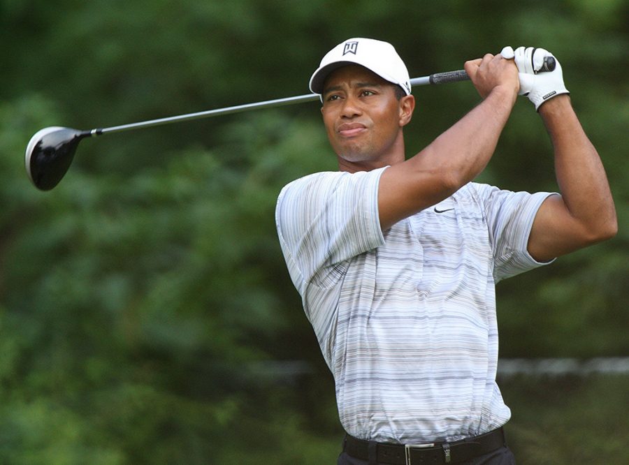 teeing off, Tiger Woods looks on after taking his first stroke on a hole during the Masters tournament