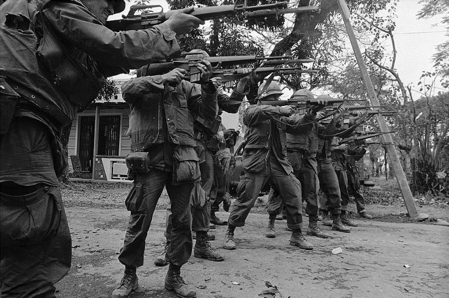 Taking aim, U.S. Marines Stand together at a Village in Vietnam during 1968.