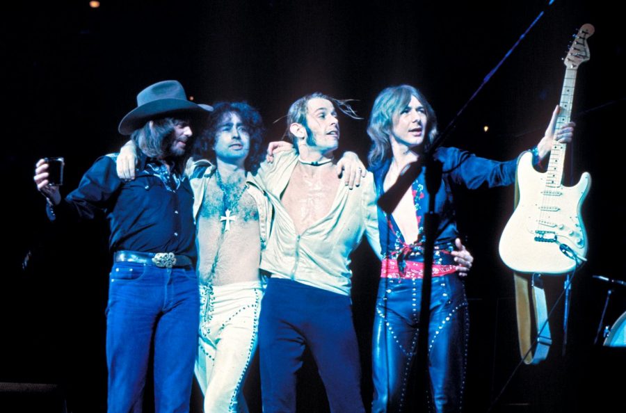 Performing at their concert, Bad Company, entertain fans with their vocals and music playing. 