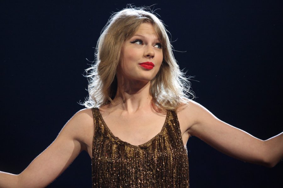 Encouraging her fans to sing along, Taylor Swift sings Shake it Off at her concert.