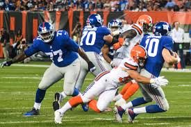 Seen here is number 77, John Jerry (left), letting a browns players through to get a free shot on number 10, Eli Manning (right).