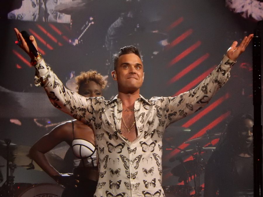 Singing to his fans, Robbie Williams,  celebrates his 12 number one album.