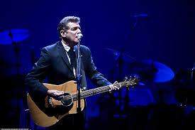 Playing guitar and singing at the concert, Glenn Frey enjoys his time before his passing. 