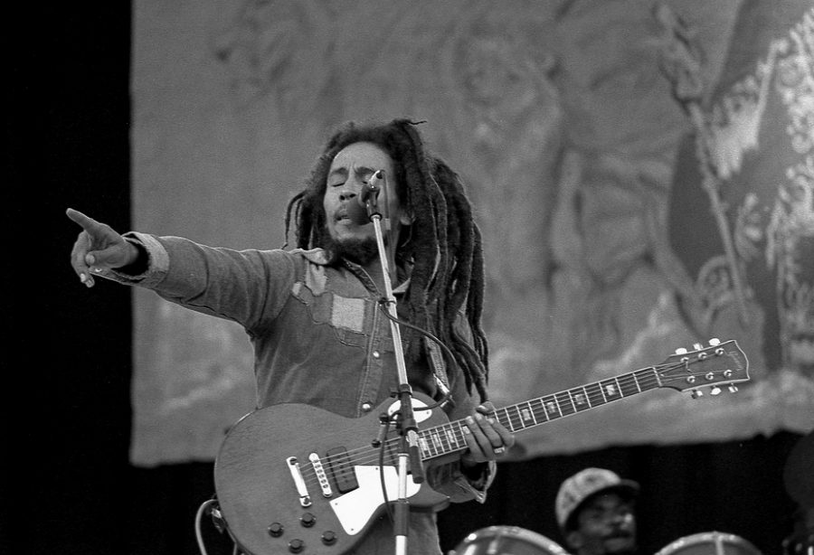 Pointing for the crowd to sing in his music, Bob Marley performs No Woman No Cry. 