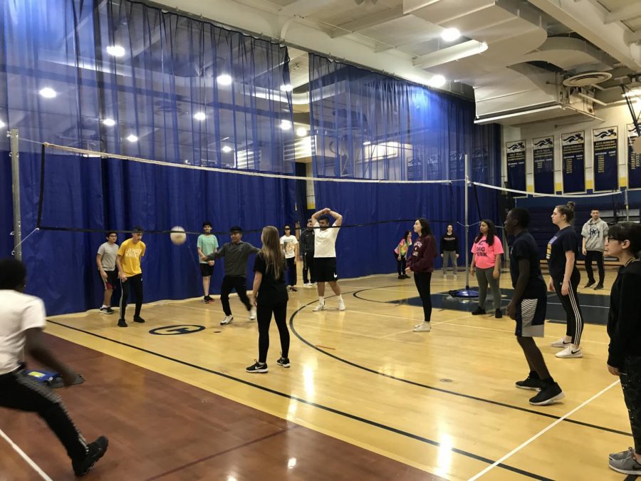 Gym students of first block playing a competitive round of volleyball.