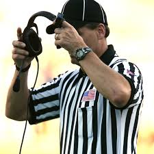 Seen here is an example of an NFL official putting on the headset and going to review the replay of a call just made on the field.