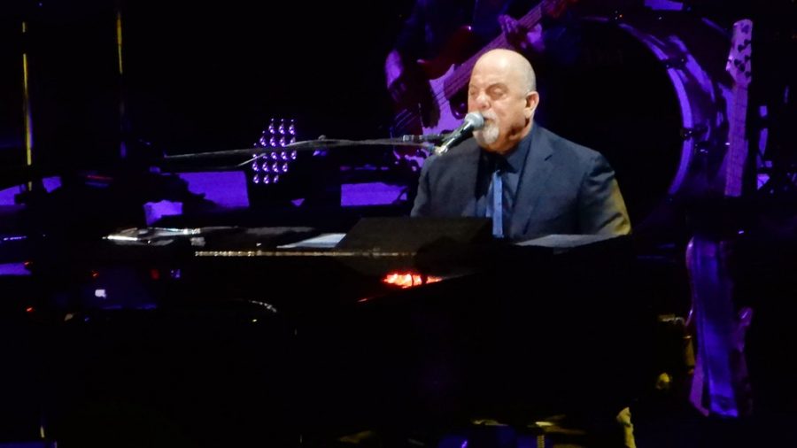 Playing the piano at the concert, Billy Joel performs for one of his songs from his album. 