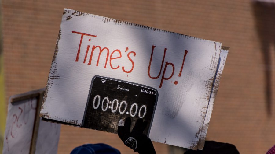 To show sexual predators and abusers their time is done, activist holds up Times Up!.