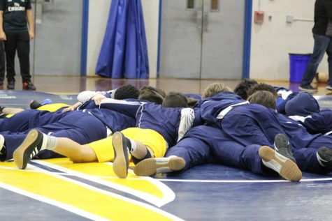 Prior to the match, the varsity wrestling team gathers together after their warm-up before each wrestler takes the mat.    
