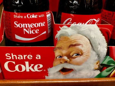 Pictured is a Coca-Cola ad that is reminiscent of older advertisements. It features Santa in a red hat. other ads show him in a red suit.
