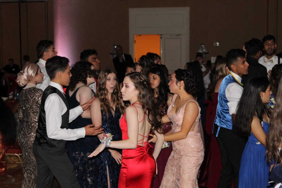 At the senior prom, students cut a rug in friend groups.