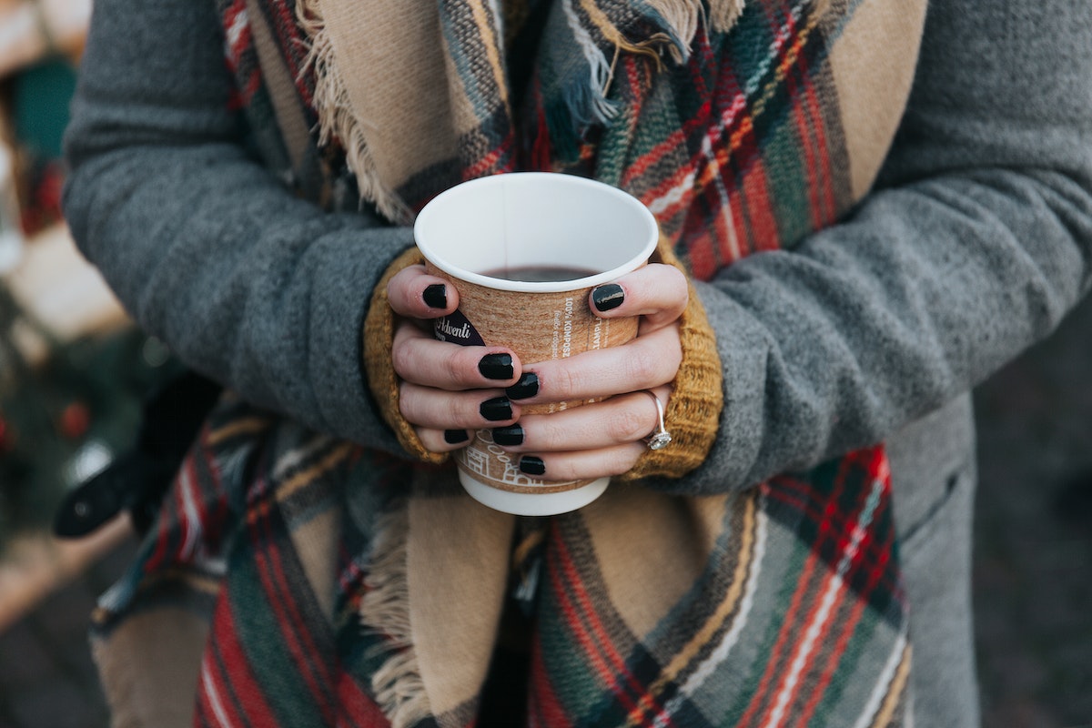 Girl holding a warm cup of coffee. 