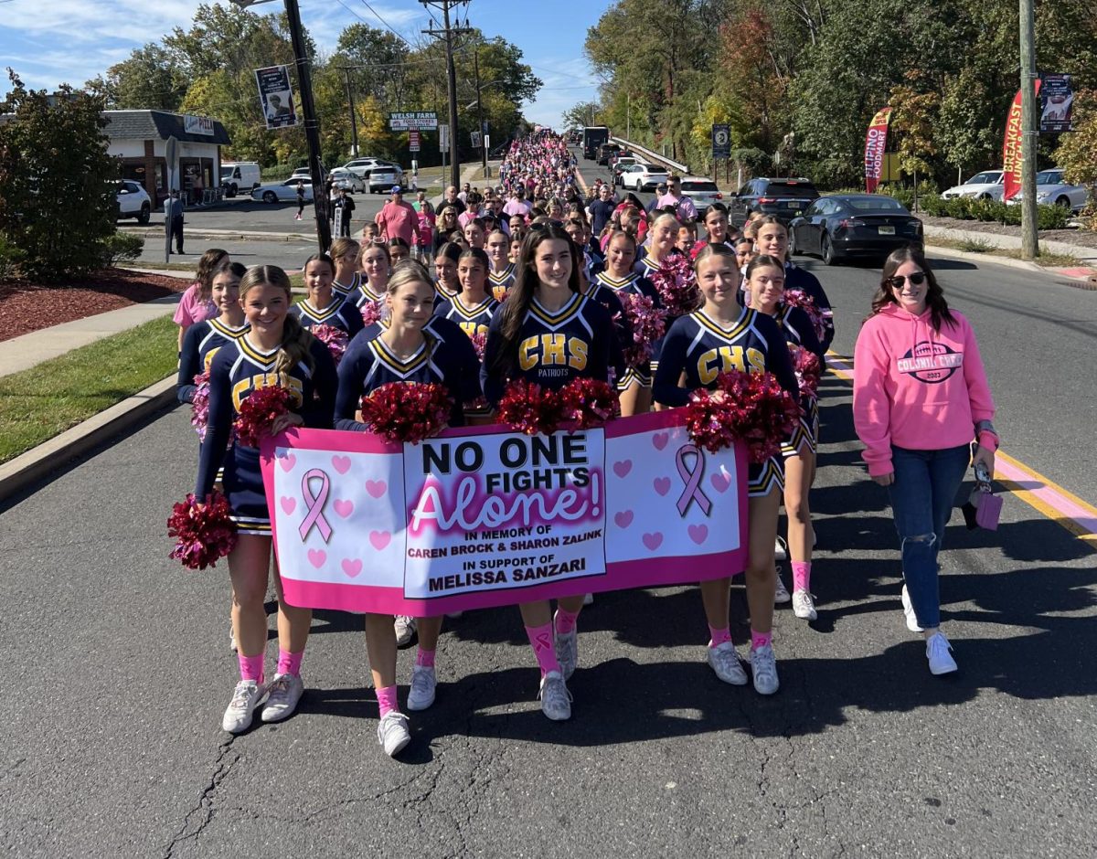 Colonia High School Cheer Team leads the 2024 Inman Avenue breast cancer walk, walking from Saint John Vianney Church to Springwood Swim club..