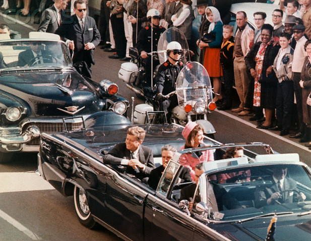 President and Mrs. John F. Kennedy smile at the crowds lining their motorcade route in Dallas, Texas, on November 22, 1963. Minutes later the President was assassinated as his car passed through Dealey Plaza.