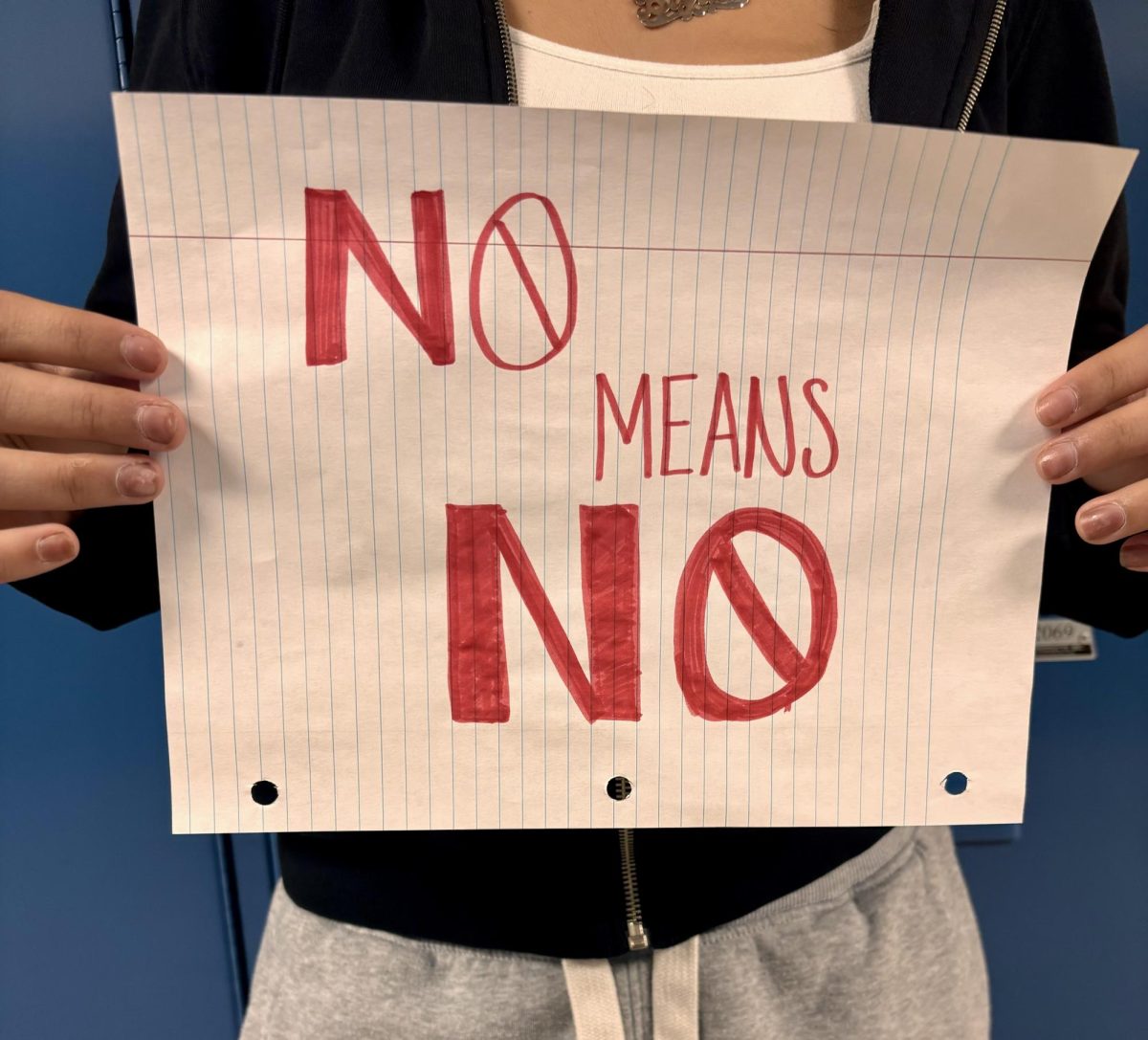 Student holds sign rasing awareness for victims of sexual assault in schools. Sexual assault is protected under Title IX. 